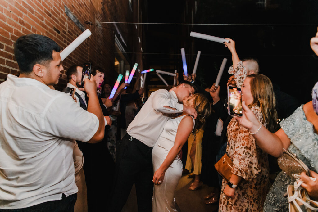 bride and groom walk through exit at wedding reception