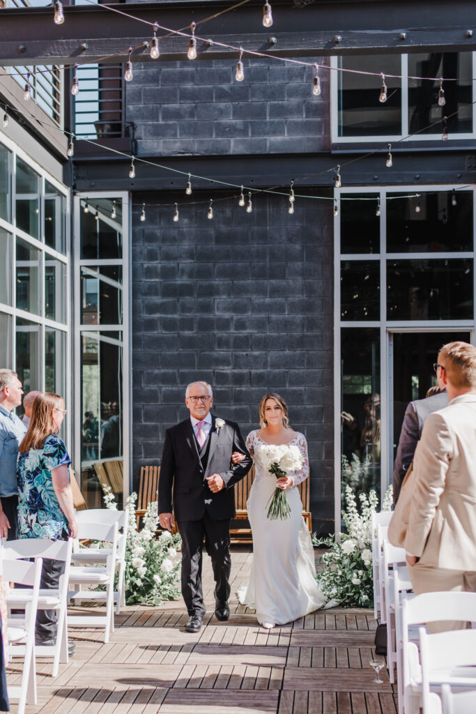 bride and her father walk down the aisle during a ceremony at excelsior in lancaster pennsylvania