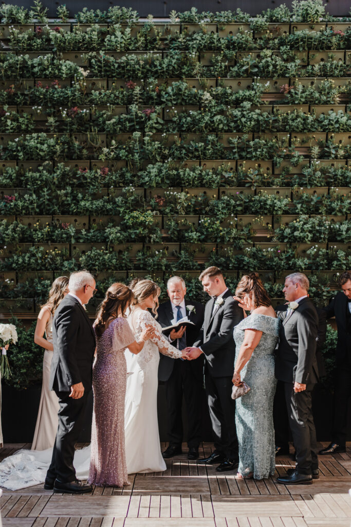 family prays around bride and groom during ceremony
